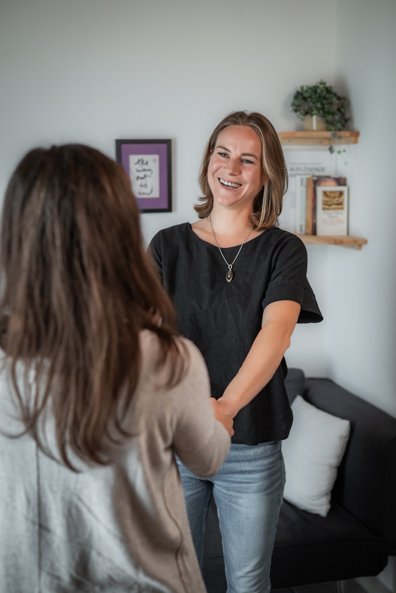 Abschiedsszene: Klientin und Hypnotiseurin stehen voreinander, lachen und halten sich die Hände.